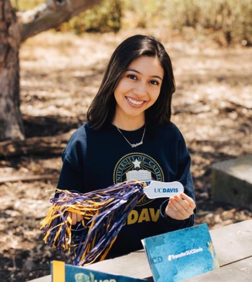 Photo of Peer Advisor in bench with UCD swag